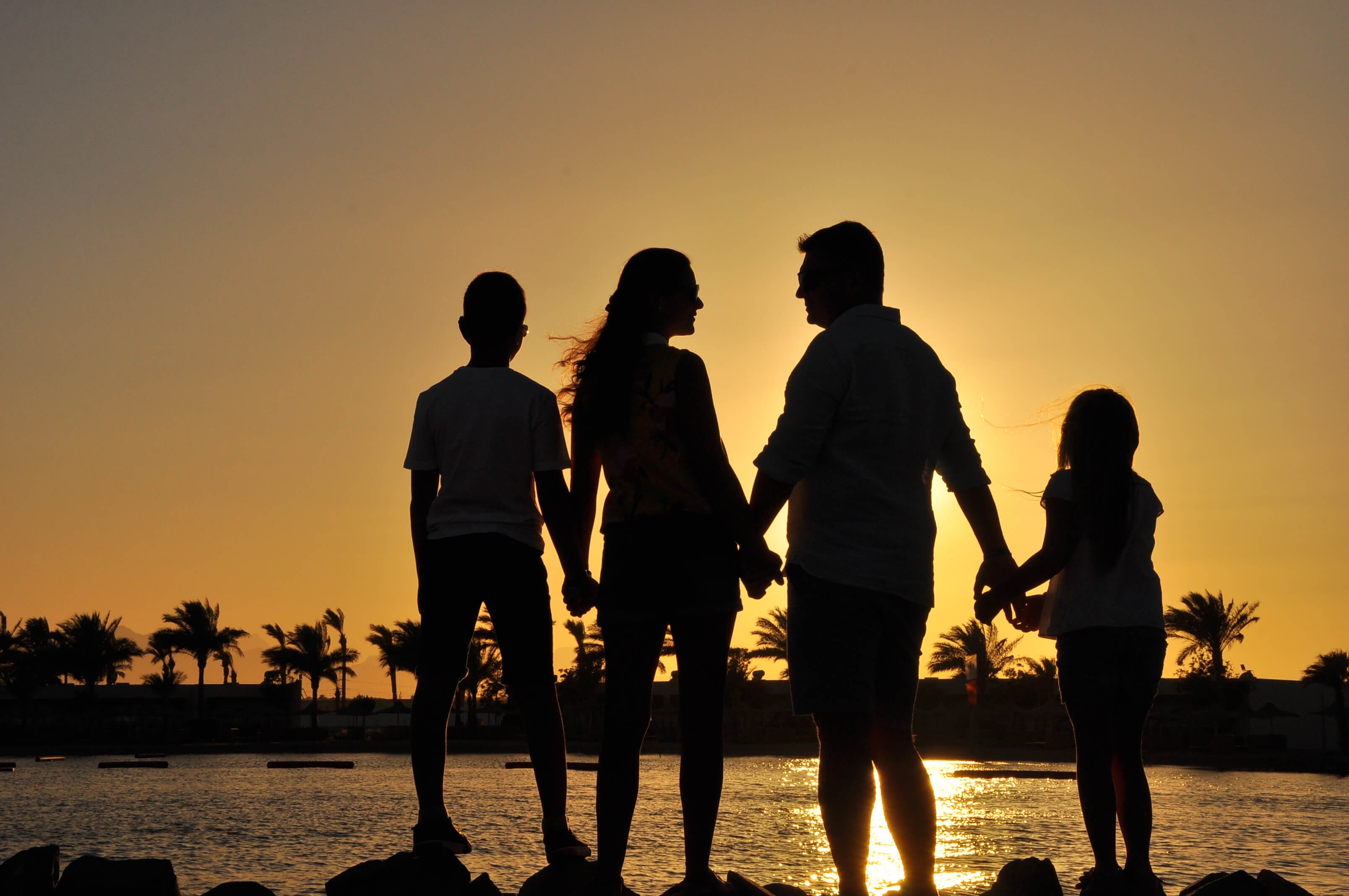 United Hands by the Red Sea - Joined hands of a family on the shore.